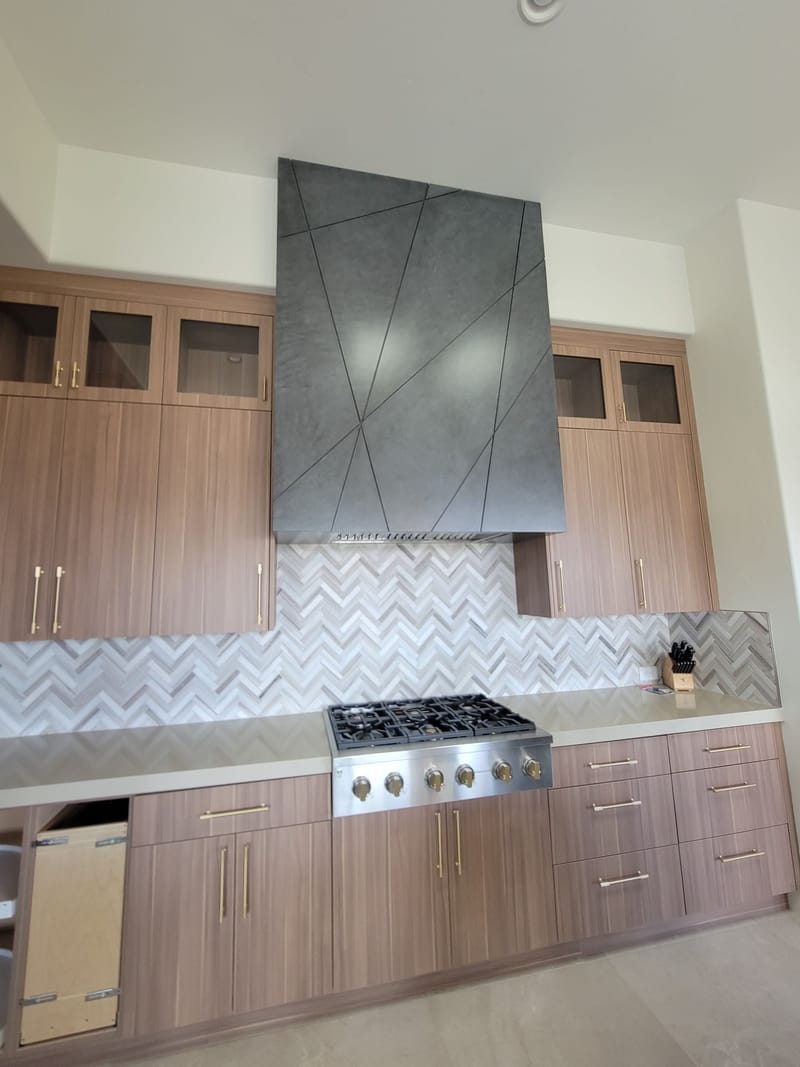 Kitchen range wall with painted walls and wood-tone cabinets
