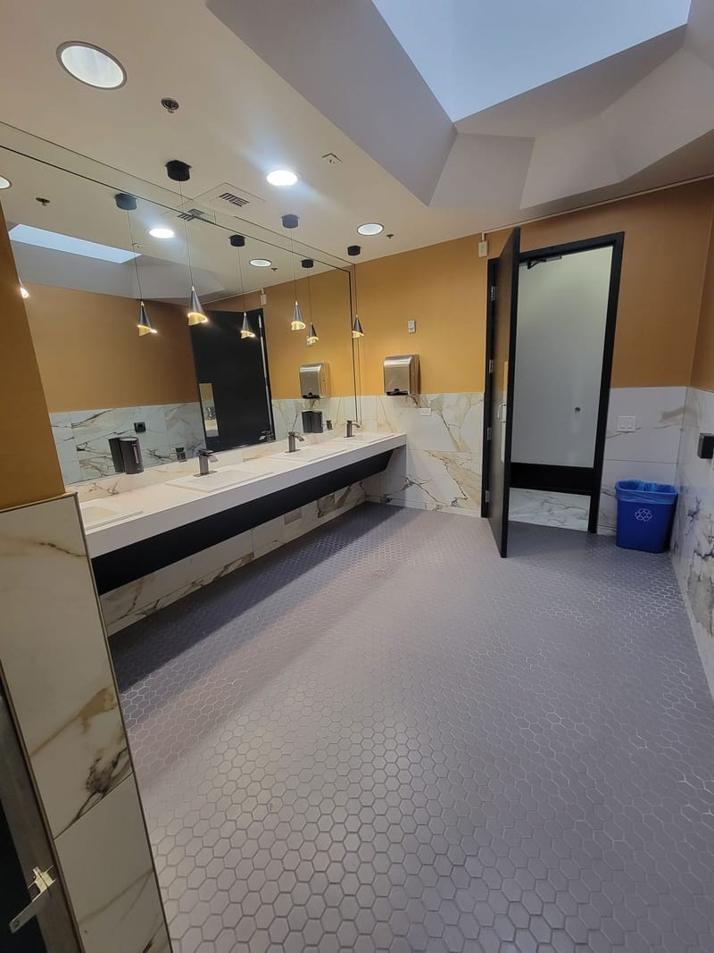 Commercial restroom with gold and marble painted walls