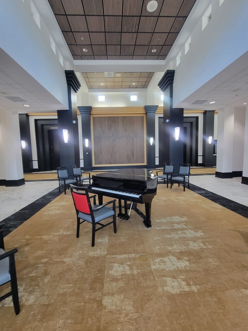Commercial lobby with grand piano and painted black columns