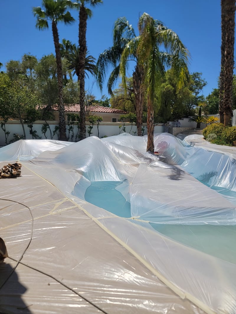 Exterior repaint prep by Mark Anthony Painting — pool and patio fully masked before spraying, Las Vegas NV